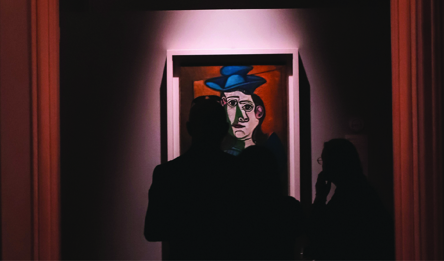 People in Art Gallery Looking at Paintings